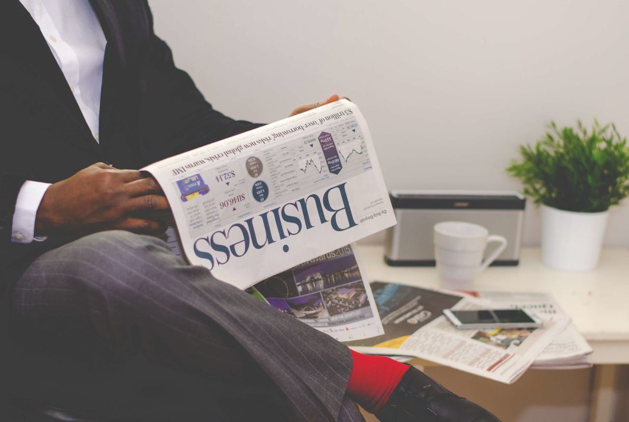 men reading business newspaper