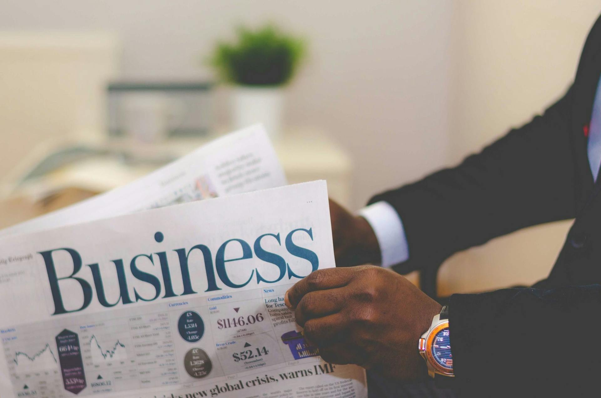 man with watch reading business newspaper